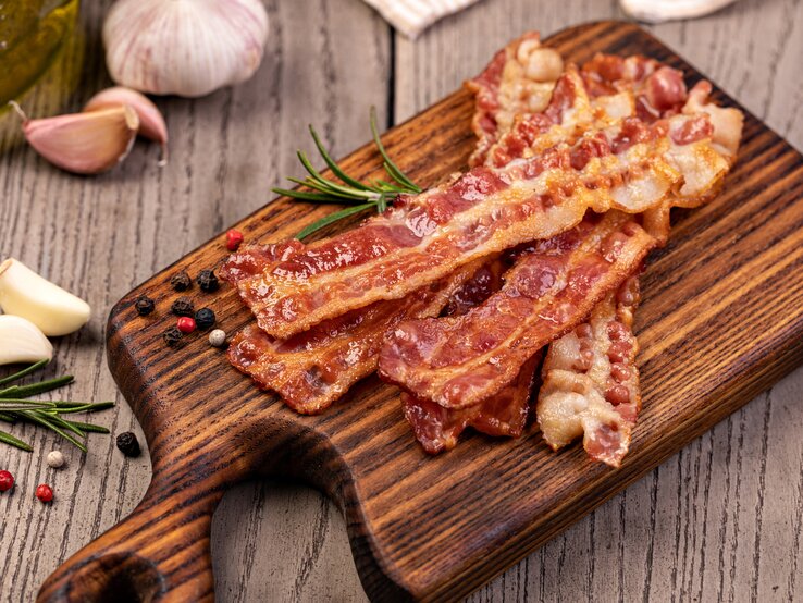 Knuspriger Bacon auf dem Holzbrett von oben fotografiert.