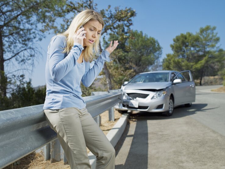 Verärgert Frau mit Handy neben ihrem kaputten Auto.