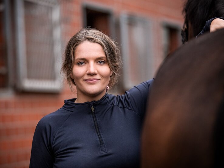 Harriet Charlotte Jensen steht neben ihrem braunen Pferd. | © lexoffice