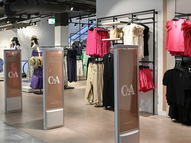 Moderner Bekleidungsladen von C&A mit Kleiderständern und Mannequins in einem Einkaufszentrum.