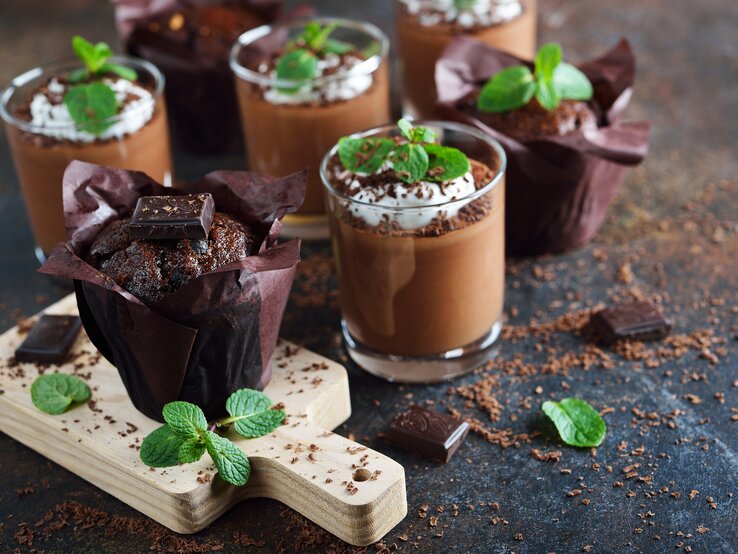 After-Eight-Mousse mit Sahne, Schokoraspeln und Minze auf dunklem Untergrund. 