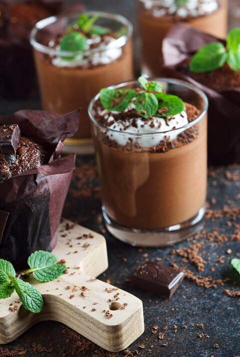 After-Eight-Mousse mit Sahne, Schokoraspeln und Minze auf dunklem Untergrund. 