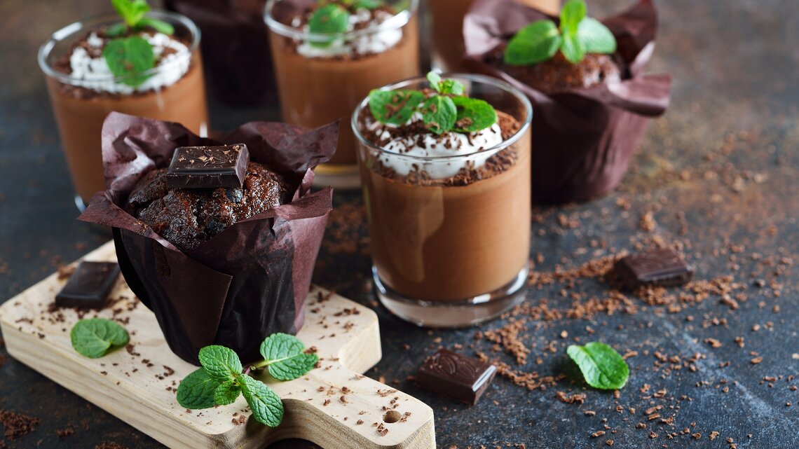 After-Eight-Mousse mit Sahne, Schokoraspeln und Minze auf dunklem Untergrund. 