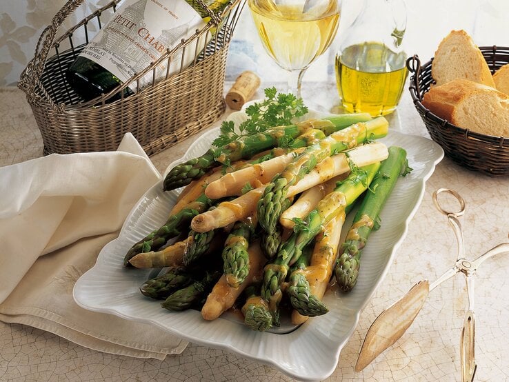 Weißer und grüner Spargel auf einem weißen Servierteller. 