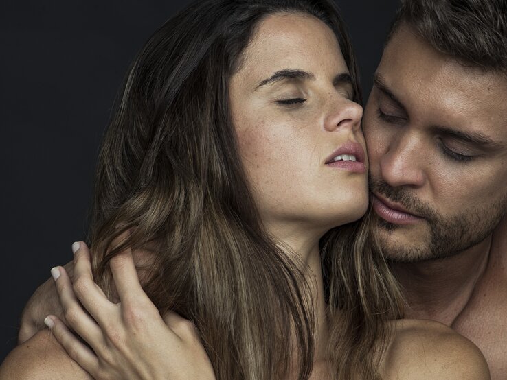 Ein Mann und eine Frau in einer intimen Umarmung, wobei der Mann seine Wange sanft an die der Frau drückt und beide die Augen geschlossen haben, was ein Gefühl von Nähe und Zärtlichkeit vermittelt.
