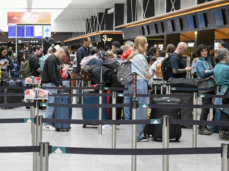 Passagiere beim Check-in Schalter in Zürich am Flughafen.