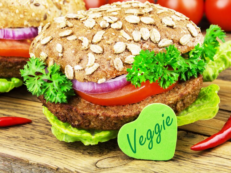 Produktion von Fleischersatz gestiegen: ein Burger mit vegetarischem Patty, Salat, Zwiebeln und Tomaten.