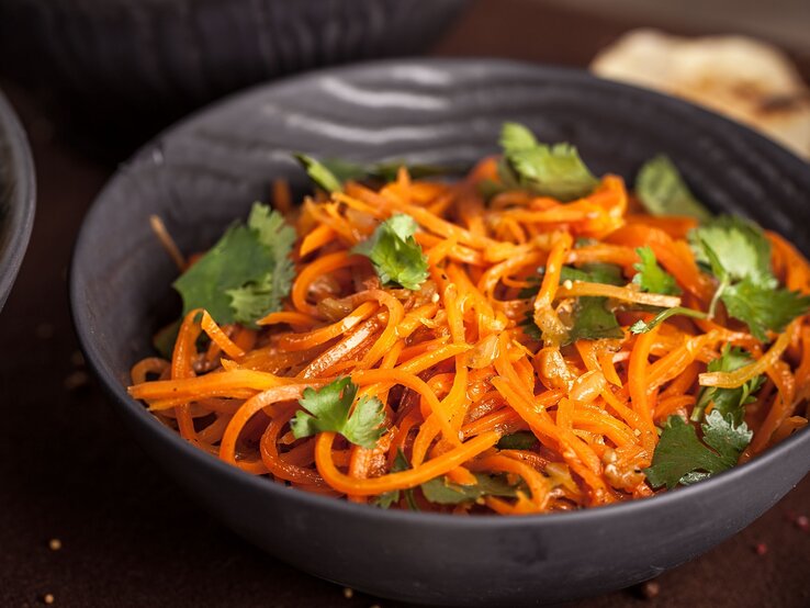 Morkowtscha-koreanischer-Moehrensalat Eine Schüssel Morkowtscha, koreanischer Möhrensalat, mit Koriander garniert.