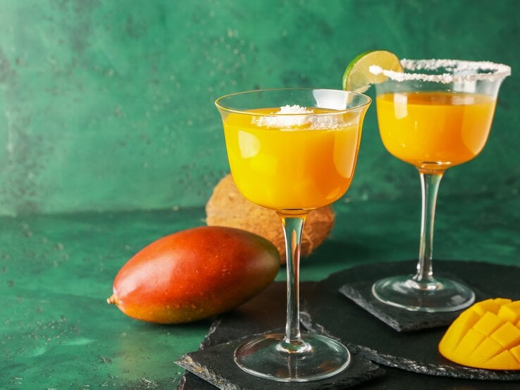 Zwei Gläser mit Mango-Margarita und Salzrand. 