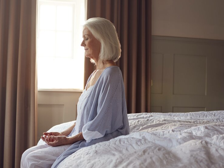 Eine Dame startet achtsam mit Meditation in den Tag.