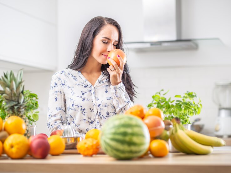Frau riecht an Zitrusfrucht