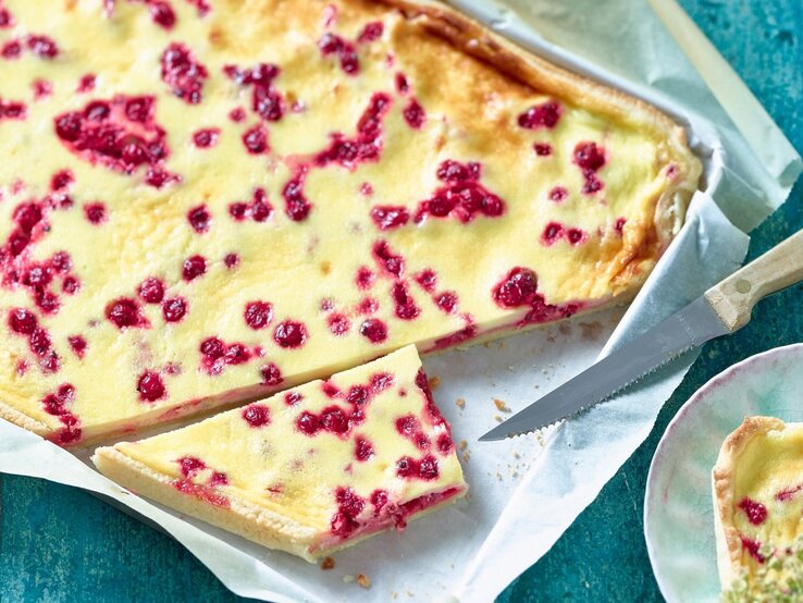 Auf einem Backblech liegt ein Johannisbeer-Schmandkuchen. Er ist cremig und leicht. 