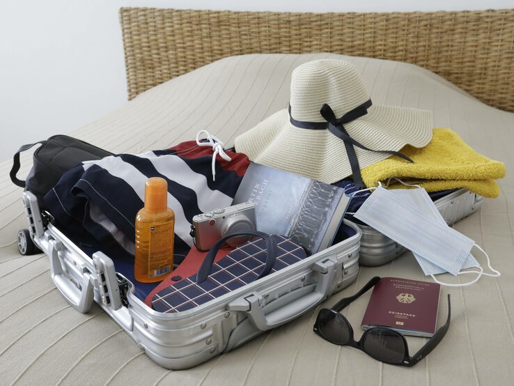 Ein kleiner Koffer, gepackt mit den wichtigsten Dingen, für den Sommerurlaub.
