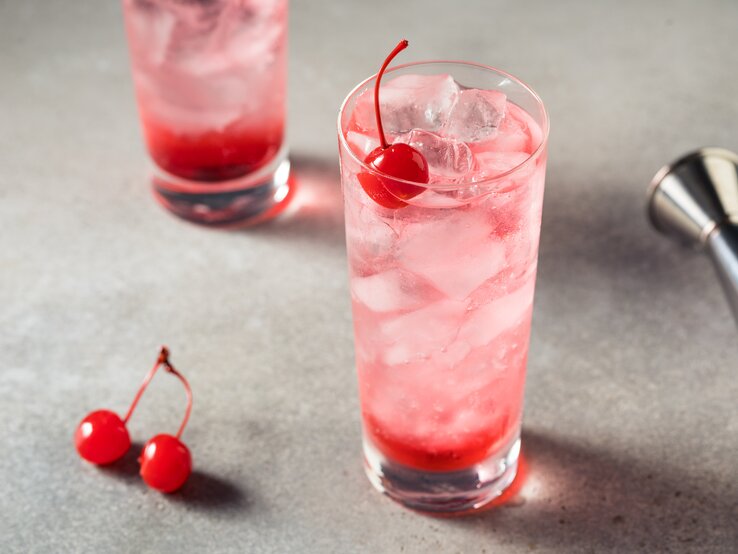 Zwei Gläser mit Dirty Shirley, verziert mit einer Cocktail-Kirsche. 