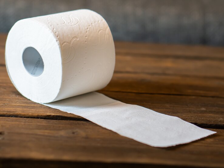 Rolle Toilettenpapier liegt auf Tisch. 