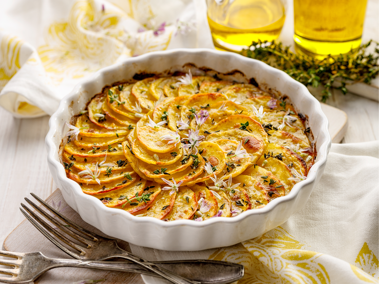 Ein indischer Kartoffelauflauf in einer runden Quiche-Form mit Blüten verziert.