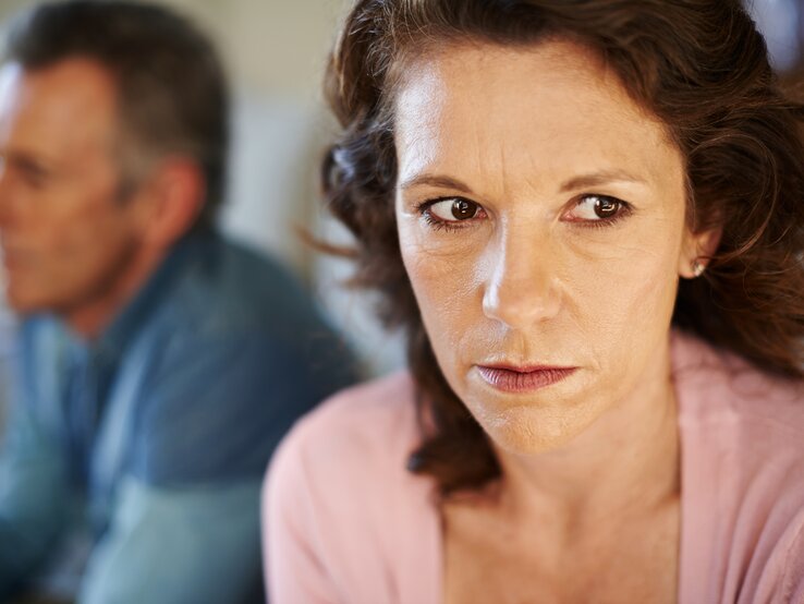 Frau die unglücklich zur Seite schaut. | © iStock/laflor