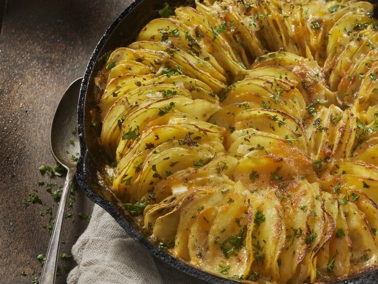 Gusseiserne Form mit überbackenen Kartoffelblättern. 