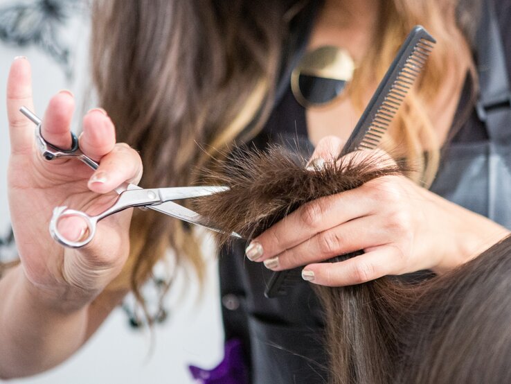 Frau lässt sich beim Friseur die Haare schneiden