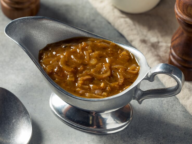 Braune Zwiebelsoße in einem Gefäß aus Edelstahl.