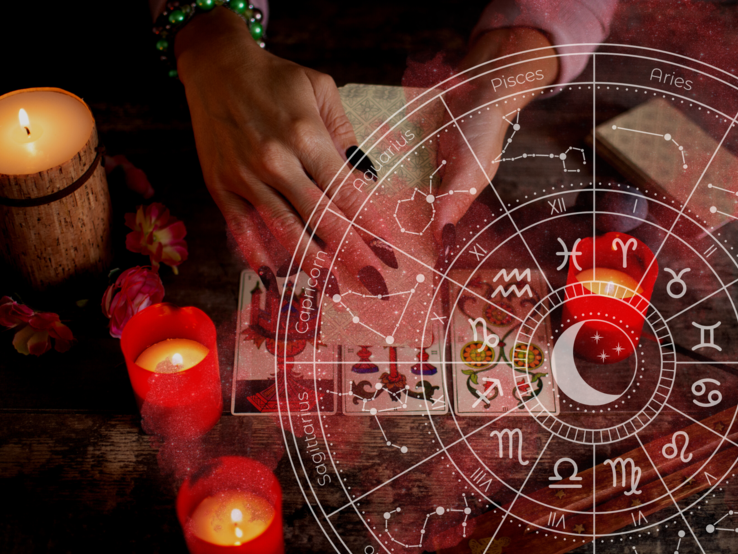 Hand einer Frau mit astrologischen Zeichen im Hintergrund.