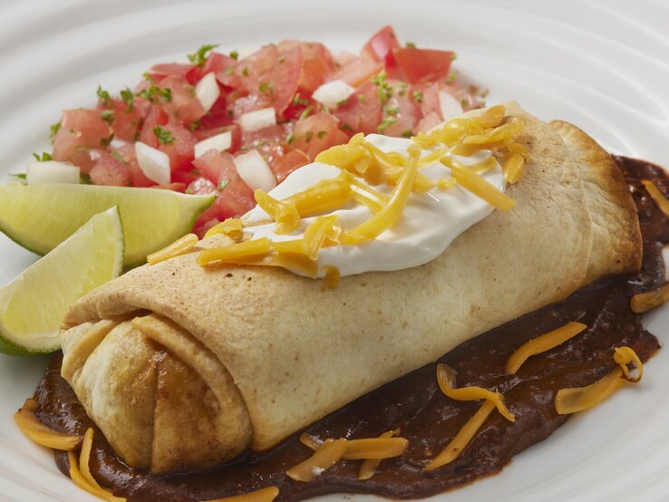Chimichanga Chimichanga mit Sour Cream und Käse überbacken zu Tomatensalat.