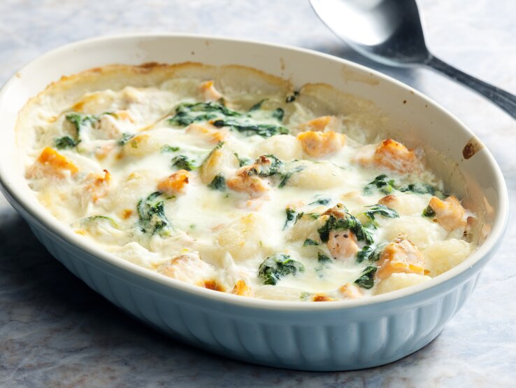 War der Tag mal wieder ordentlich gemein zu Ihnen? Dieser Gnocchi-Lachs-Auflauf mit Spinat ist da wie Balsam zu Ihrer Seele. Gnocchi-Lachs-Auflauf mit Spinat in weißer Auflaufform.
