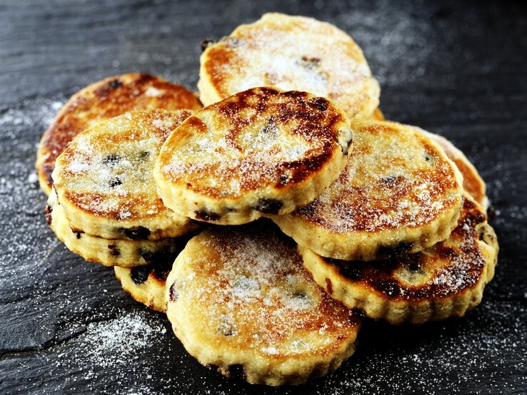 Mehrere Welsh Cakes auf einem dunklen Schieferuntergrund.