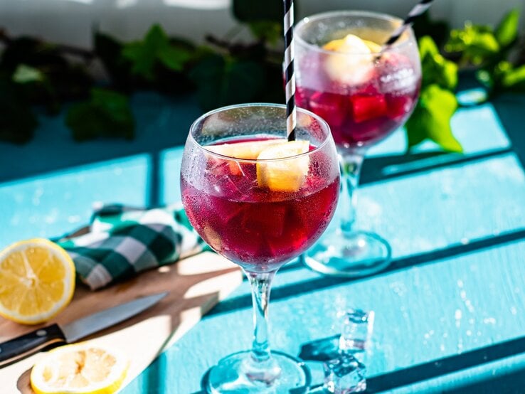 Zwei Gläser spanische Rotwein-Limonade auf einem blauen Tisch.