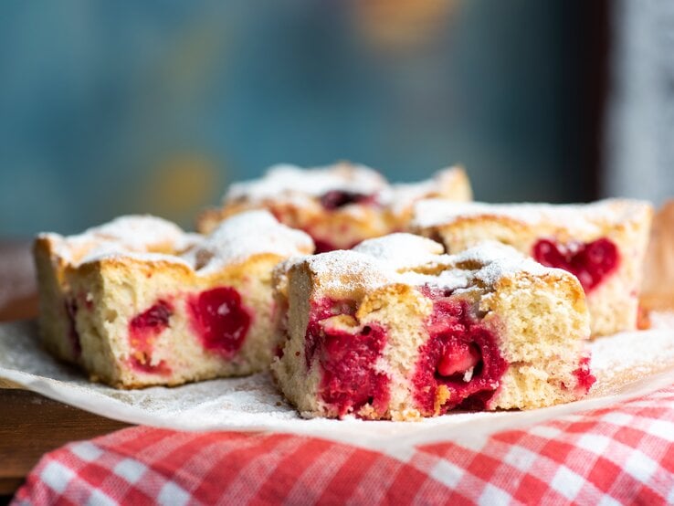 Süßkirsch-Kuchen auf Küchenpapier vor blauem Hintergrund. 