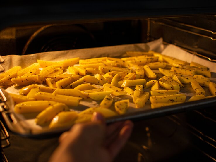 Ein Backblech mit Pommes im Ofen.