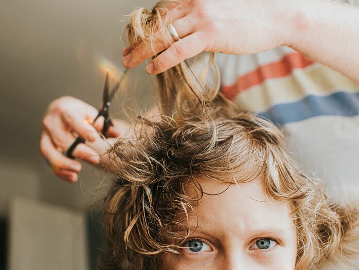 Einer jungen Frau werden die Haare geschnitten