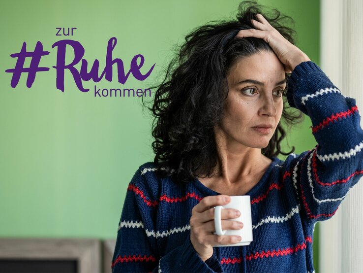 Eine nachdenkliche Frau mit dunklem Haar hält eine Tasse in ihrer Hand und blickt in die Ferne, während sie ihre andere Hand an ihren Kopf legt. Sie trägt einen gestreiften Pullover und steht in einem Raum mit grünen Wänden. Neben ihrem Kopf steht der Text "zur #Ruhe kommen" in lila Schrift, was auf einen thematischen Fokus auf Entspannung oder Selbstfürsorge hinweist.