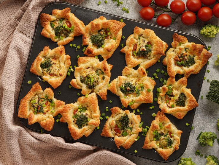 Brokkoli-Muffins mit Mozzarella, Tomaten und Schnittlauch in Muffinform.