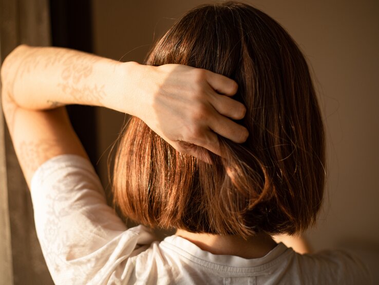 Eine Frau fasst sich in die Haare.