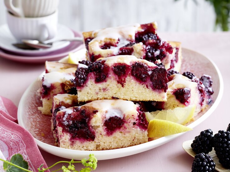 Brombeer-Joghurt-Kuchen auf einem rosa Teller.