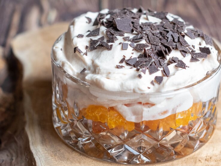 Dessert mit Löffelbiskuit und Mandarine auf Holz