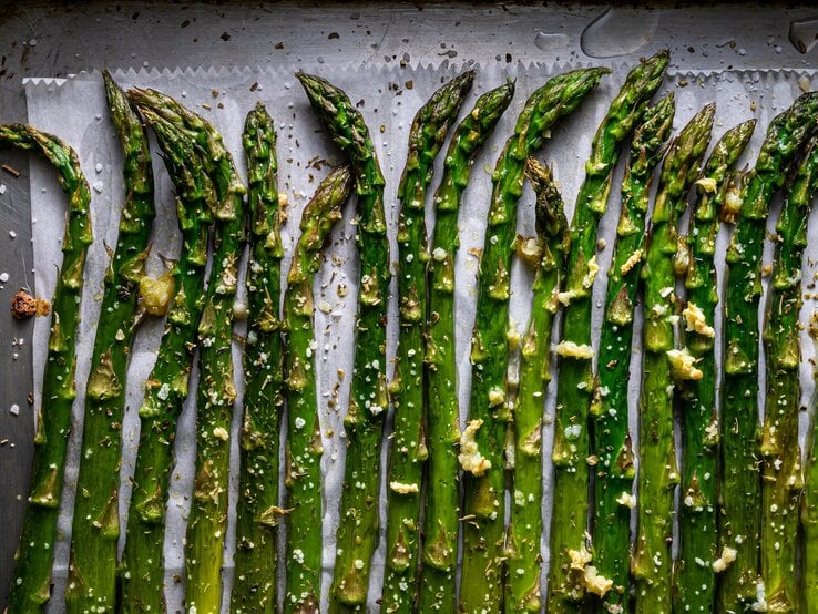 Grüner Spargel auf einem Backblech direkt von oben fotografiert.