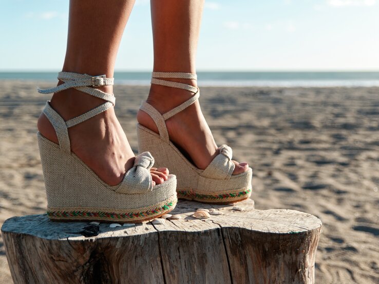Eine Frau trägt den Sommertrend 2023 an den Füßen: Wedge-Schuhe.