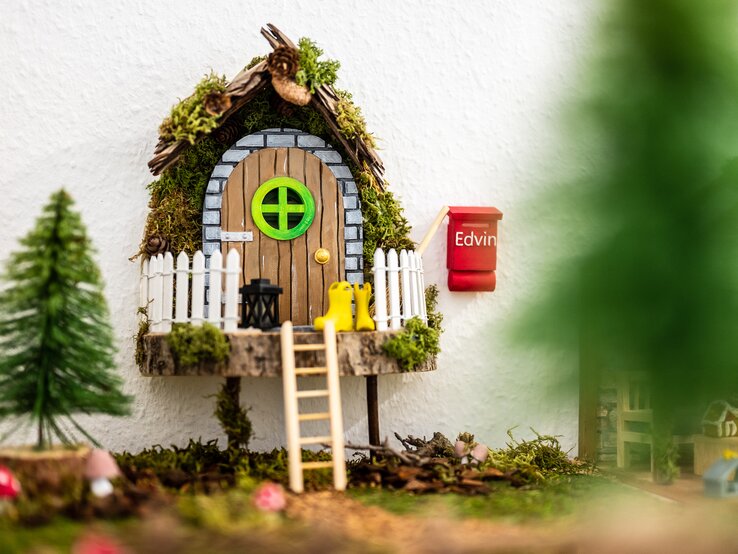 Ein selbst gebastelte Wichteltür mit Briefkasten, Tannenbaum und Leiter. 