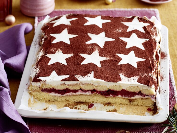 Glühwein-Tiramisu-Schnitten Glühwein-Tiramisu-Schnitten serviert auf einem weißen Teller, daneben weihnachtliche Deko-Elemente.