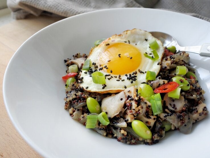 Eine Portion asiatische Quinoa-Bowl in einer weißen Schüssel.