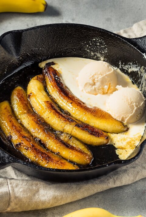 Eine Pfanne mit Rum-Bananen mit Vanilleeis.