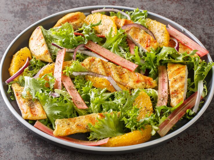 Eine graue Schüssel mit dem Salat auf einem mattgrauen Untergrund.