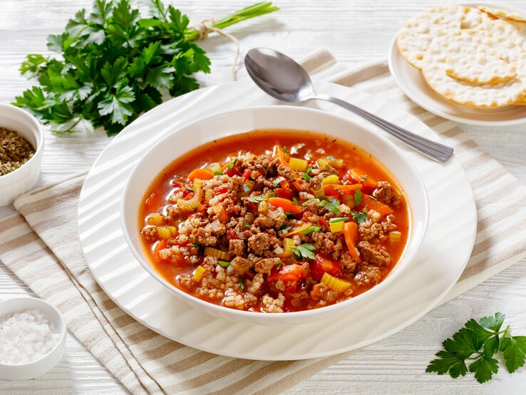 Tomatige Hackfleisch-Suppe auf weißem Teller. 