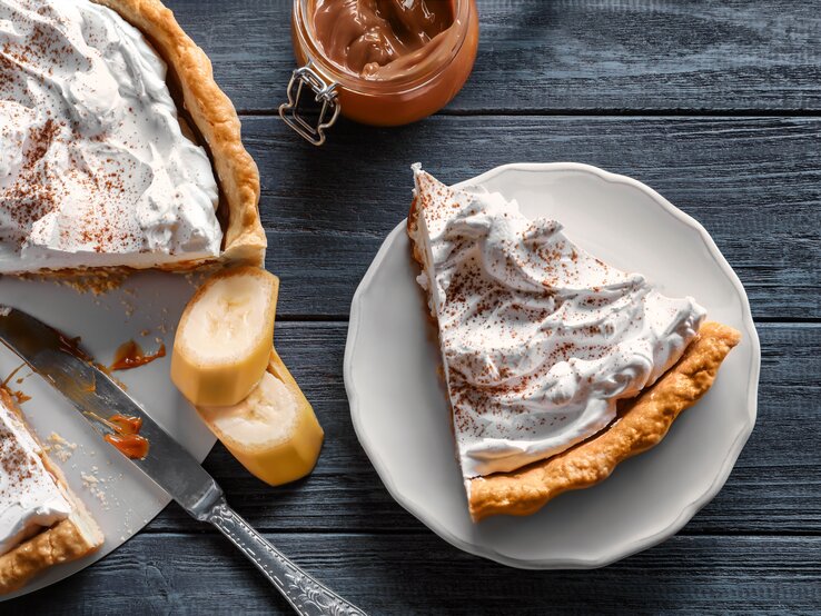 Draufsicht auf eine Torte mit mürbem Boden, Bananen und feiner Creme.