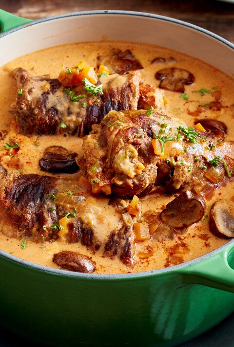 Rindsrouladen mit Knödelmix / gusseiserner Topf / Draufsicht schräg / Untergrund aus Holz