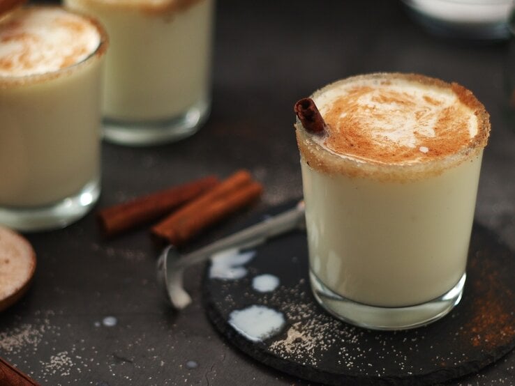 Drei Gläser mit dem Eierlikör-Milkshake auf einem dunklen Untergrund.