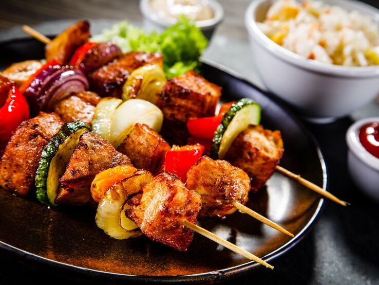 Schweinefilet-Spießen-mit-Grillgemuese Saftig-zarte Schweinefiletspieße mit Gemüse frisch gegrillt auf dem Teller.