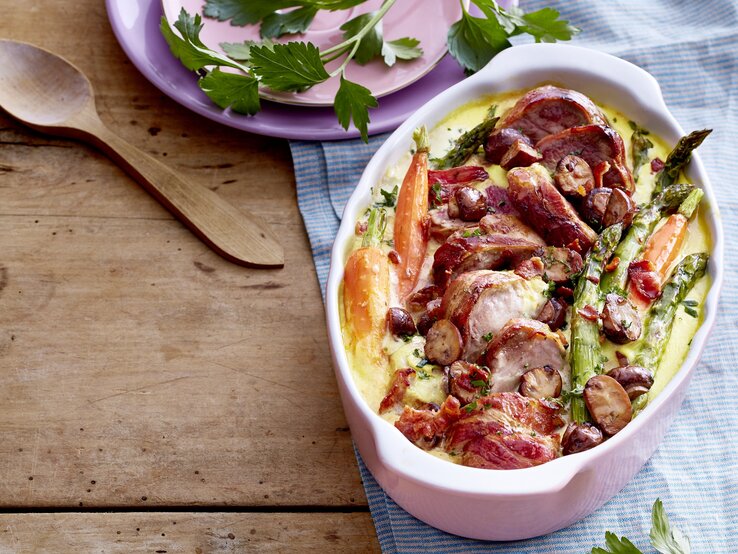 Schweinefilet mit Spargel-Gemüse in Auflaufform auf dem Tisch serviert.